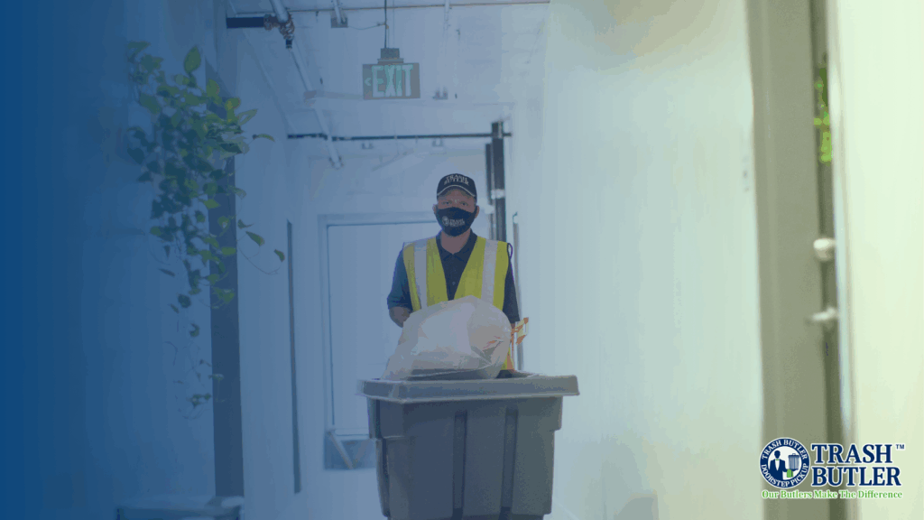 A uniformed Trash Butler taking out a client’s refuse